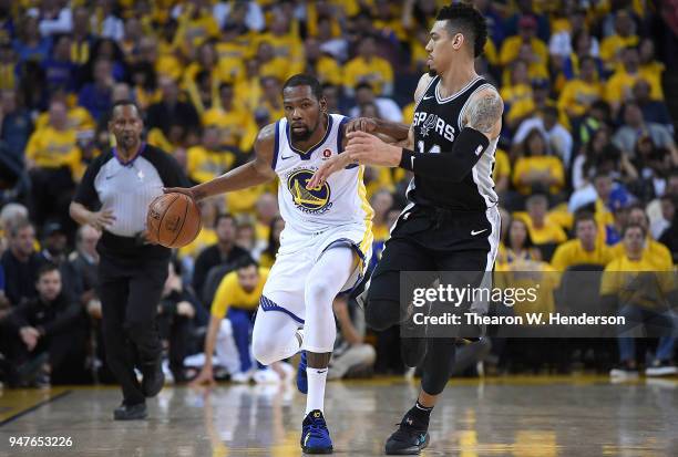 Kevin Durant of the Golden State Warriors dribbles the ball up court while being closely guarded by Danny Green of the San Antonio Spurs in the third...