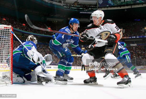 Michael Del Zotto of the Vancouver Canucks checks Jakob Silfverberg of the Anaheim Ducks during their NHL game at Rogers Arena March 27, 2018 in...