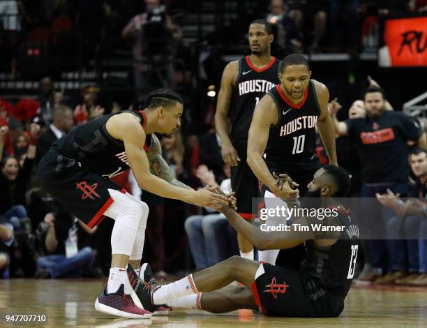 Eric Gordon of the Houston Rockets and Gerald Green help James Harden to his feet in the second half during Game One of the first round of the 2018...