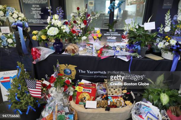 Flowers, cards, and gift baskets are laid amid a memorial for slain Yarmouth K-9 officer Sean Gannon at the Yarmouth Police Station in Yarmouth, MA...