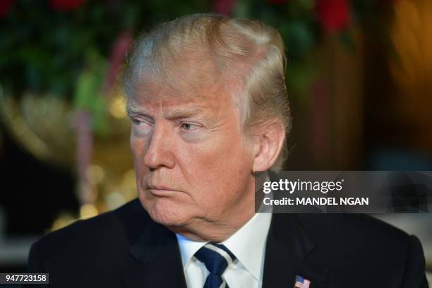 President Donald Trump listens to Japanese Prime Minister Shinzo Abe as he arrives for talks at Trump's Mar-a-Lago resort in Palm Beach, Florida, on...