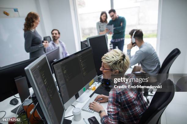 young female computer programmer working on computer - web programmer stock pictures, royalty-free photos & images