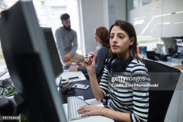 young female computer programmer working on computer - web programmer stock pictures, royalty-free photos & images
