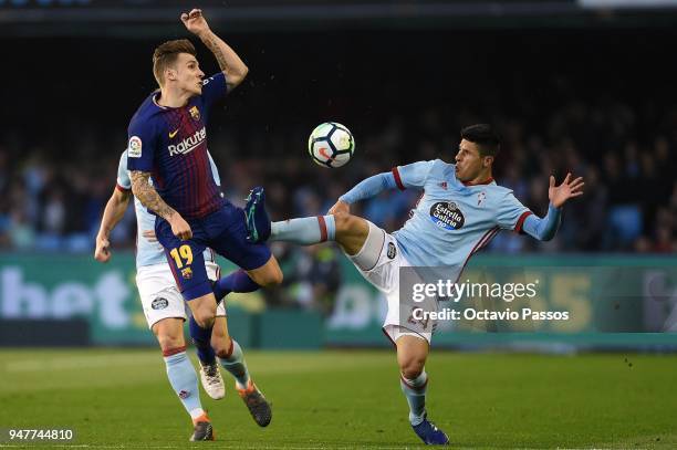 Facundo Roncaglia of Celta de Vigo competes fo the ball with Lucas Digne of Barcelona during the La Liga match between Celta de Vigo and Barcelona at...