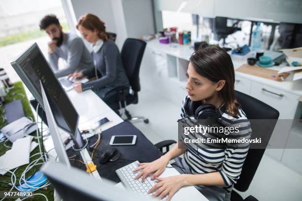 young female computer programmer working on computer - web programmer stock pictures, royalty-free photos & images