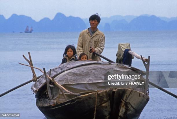 Père avec ses enfants sur une jonque dans la Baie d'Halong Vietnam.