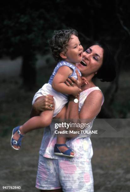 Femme tenant son bébé dans les bras.