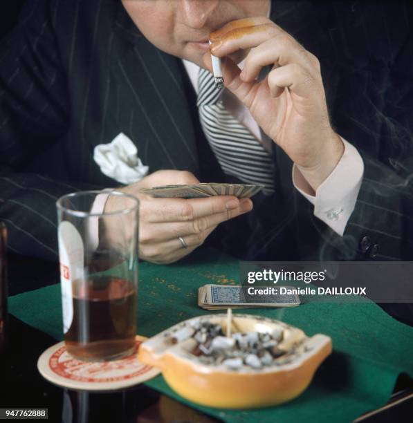 Joueur de cartes fumant et buvant de l'alcool.