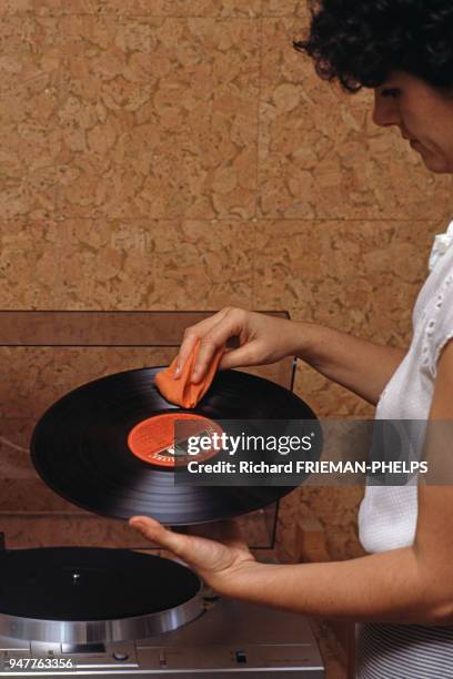 Femme nettoyant un disque vinyle.