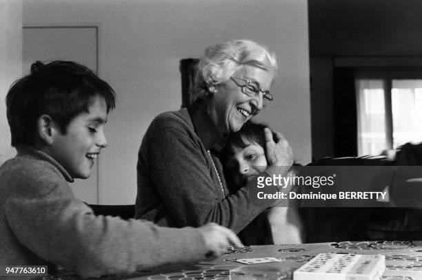 Enfants jouant aux cartes avec leur grand mère.