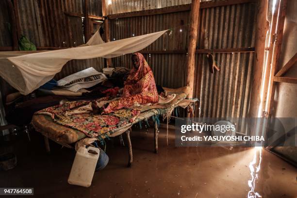 Blind woman sits on a bed in a flooded shelter after a heavy rainy season downpour at the Dadaab refugee complex, in the north-east of Kenya, on...