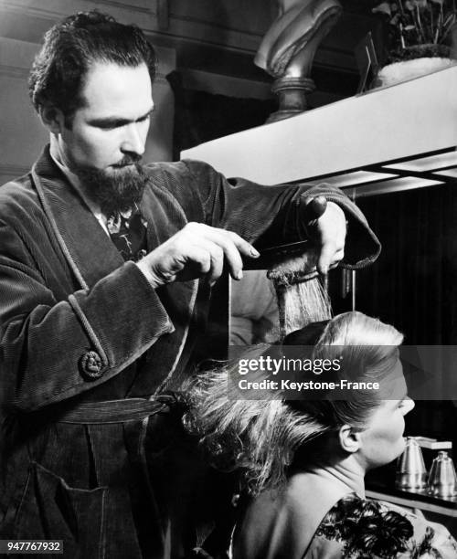 Une femme se fait poser des bigoudis pour une permanente chez son coiffeur.