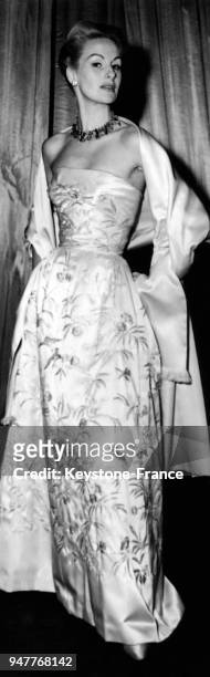 Mannequin présentant une robe "La vie en rose" en satin rose, avec son étole. Collection automne 54. Modèle Jacques Fath à l'hôtel Dorchester,...