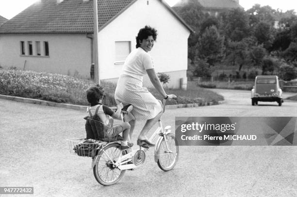 Femme à vélo avec son enfant en France.