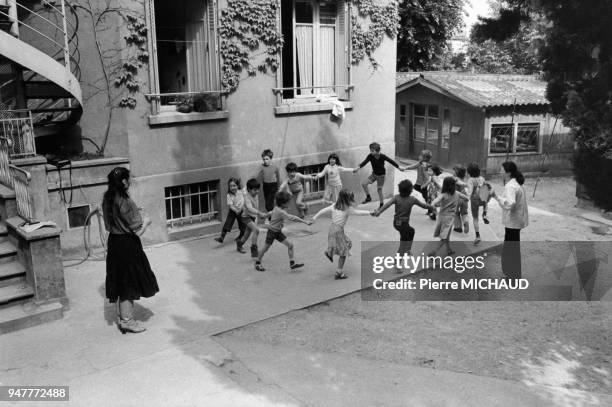 Enfants faisant la ronde dans la cour de récréation de leur école en France.