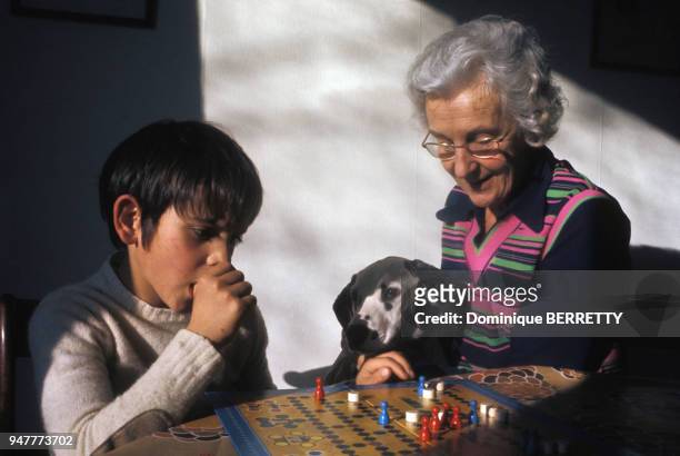 Grand-mère jouant à un jeu de société avec son petit fils, en France.