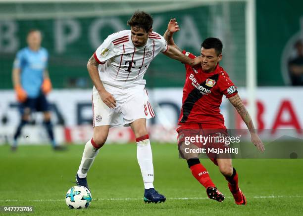 Charles Aranguiz of Leverkusen and Javier Martinez of Muenchen battle for the ball during the DFB Cup semi final match between Bayer 04 Leverkusen...