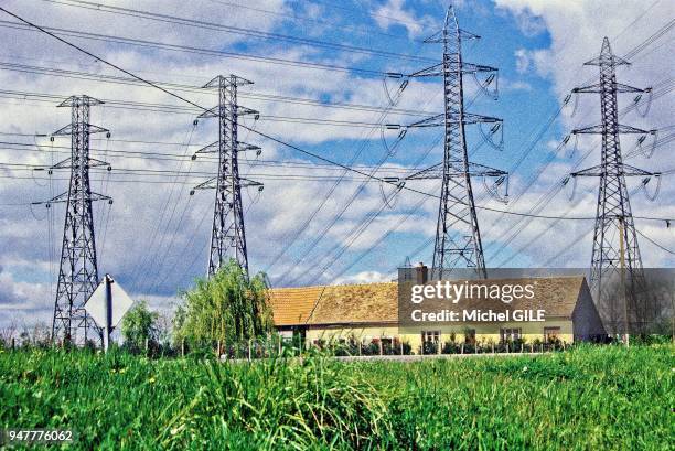 Maison au pied de trois pylones haute tension, Sarthe, France.