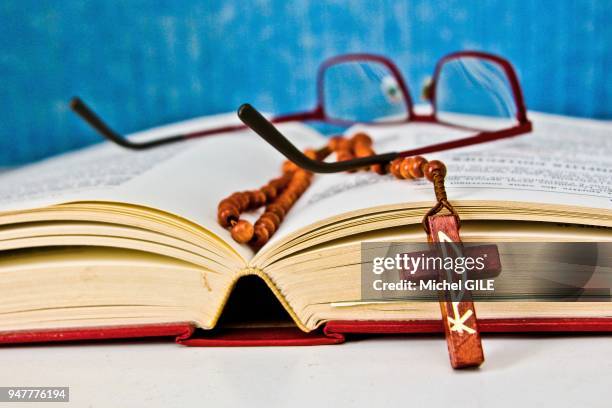 Lunettes de vue et chapelet en bois de buis sur un livre, France.