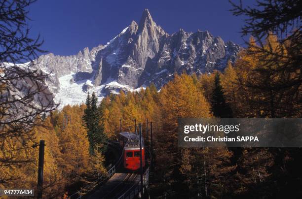 Train du chemin de fer du Montenvers devant l'aiguille du Petit Dru dans le massif du Mont-Blanc, en Haute-Savoie, France.