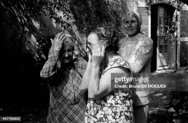 Groupe de trois femmes agées dont l'une se bouche les oreilles lors de la bravade de Saint-Tropez France.
