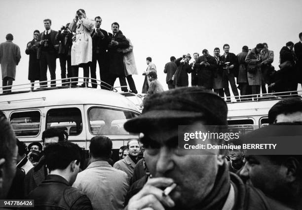 Photographes perchés sur des camions pour photographier un événement en France.