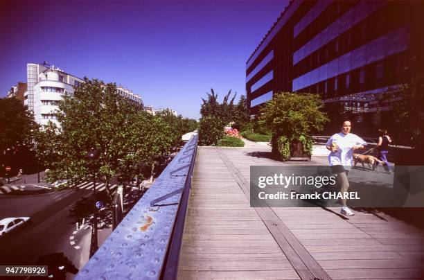 Joggeuse sur le jardin suspendu de la Coulée verte, Paris, France.