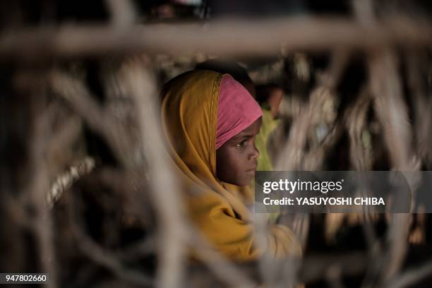 Somali refugee girl stands in a makeshift shelter at Dadaab refugee complex, in the north-east of Kenya, on April 16, 2018. The Dadaab refugee...