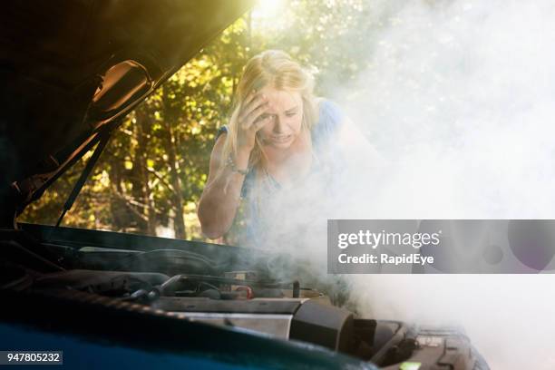 fumée se déverse de moteur de voiture de la jeune femme - roadside photos et images de collection