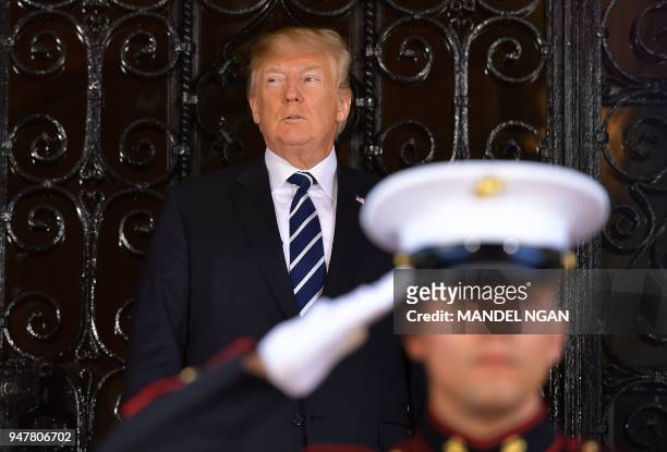 President Donald Trump waits for the arrival of Japan's Prime Minister Shinzo Abe for talks at Trump's Mar-a-Lago resort in Palm Beach, Florida on...