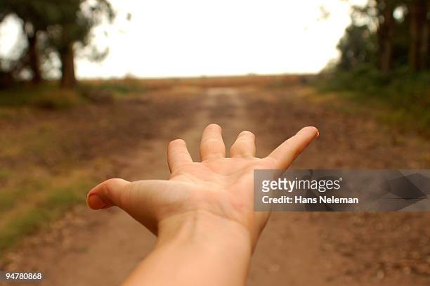 close-up of a person's palm extended toward a dirt road, la pampa, argentina - pampa argentine ストックフォトと画像