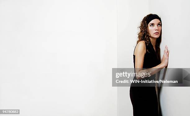 woman trying to listen through the wall - espiar una conversación fotografías e imágenes de stock