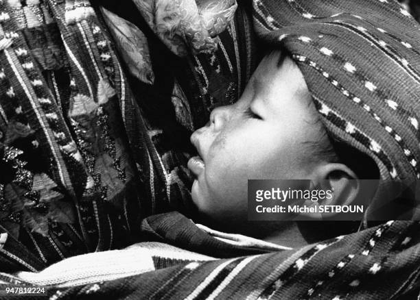 Enfant indien porté sur le dos de sa mère au Guatemala.