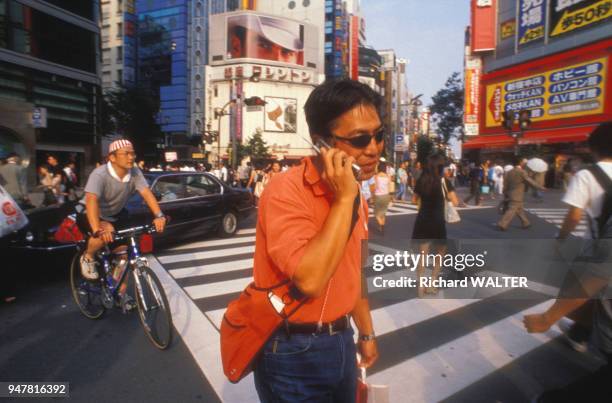 Piéton utilisant son téléphone portable dans la rue au Japon.