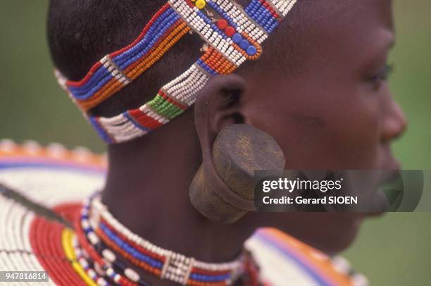 Portrait d'une jeune femme Maasaï portant des colliers et des morceaux de bois dans ses lobes d'oreilles dans la réserve du N'goron'goro, en Tanzanie.