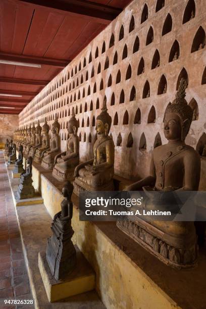 view of many old and aged buddha statues at the wat si saket (sisaket) temple's cloister in vientiane, laos. - wat si saket imagens e fotografias de stock