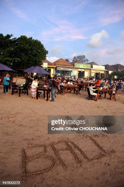 Inscription BALI sur le sable et touristes sur la plage de Jimbaran le 14 Juin 2015, Bali Indonesie.