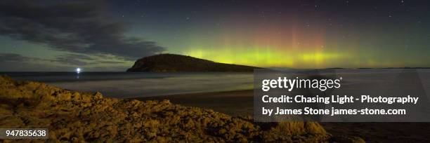 aurora australis over betsey island with moonlit beach in foreground - southern lights foto e immagini stock