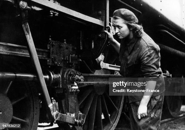 Cette jeune demoiselle âgée de 17 ans vérifie la locomotive dont elle a la responsabilité, en Tchécoslovaquie.