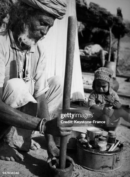 Le viel homme concocte un antidote au venin de serpent en pilant certains ingrédients naturels, en Inde.