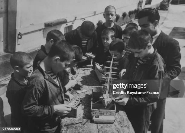 Sur le 'Tornado', l'Asile flottant espagnol, les enfants construisent des bateaux miniatures avec des allumettes, en Espagne en 1935.