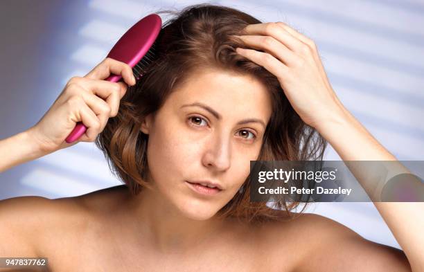 young woman brushing her hair - changed for the better stock-fotos und bilder