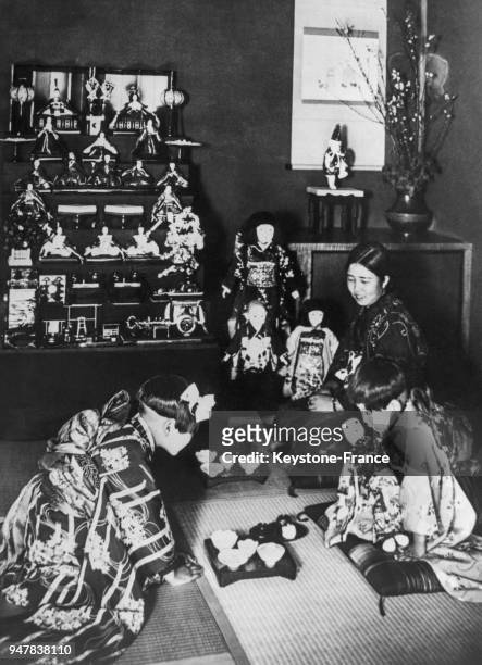 De jeunes japonaises célèbrent la 'fête des poupées' pendant la cérémonie du thé où trônent à la place d'honneur les poupées figurant l'Empereur et...