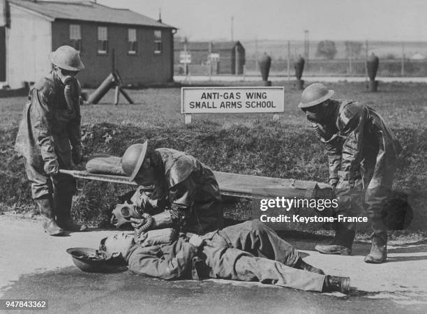 Des soldats ambulanciers, vêtus de la nouvelle combinaison de protection contre les produits chimiques, portent secours à un homme gazé, au...