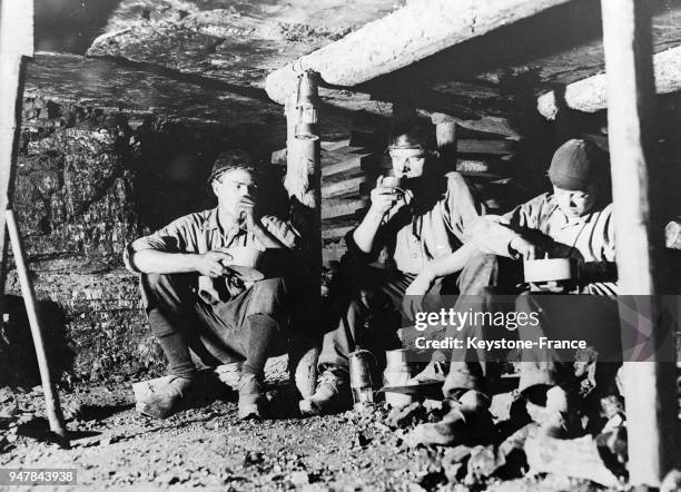 Mineurs à la pause déjeuner dans une mine en Angleterre, au Royaume-Uni en 1934.