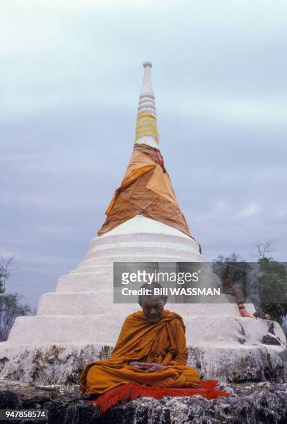 Moine bouddhiste en méditation devant un stupa sur le col des Trois Pagodes, à la frontière entre la Thaïlande et le Birmanie, en mars 1987.