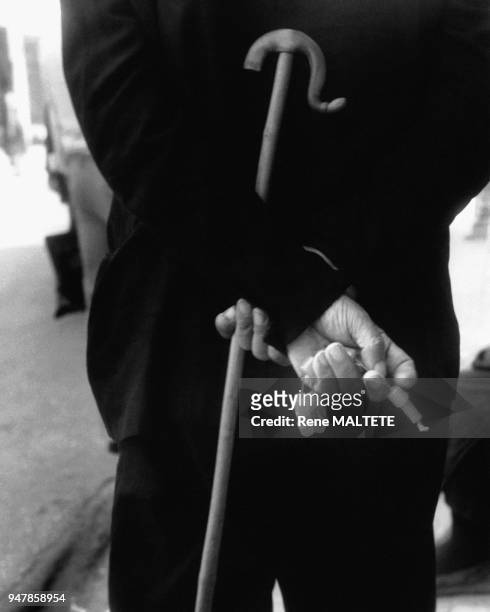 Homme de dos portant un chapelet dans les mains et la canne de berger, en Grèce en 1977.