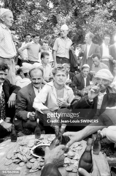 Hommes rassemblés pour boire du raki lors d'un mariage, dans la région de Shkodër, en 1964, Albanie.