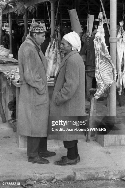 Hommes discutant sur le marché à Alger, circa 1960, Algérie.