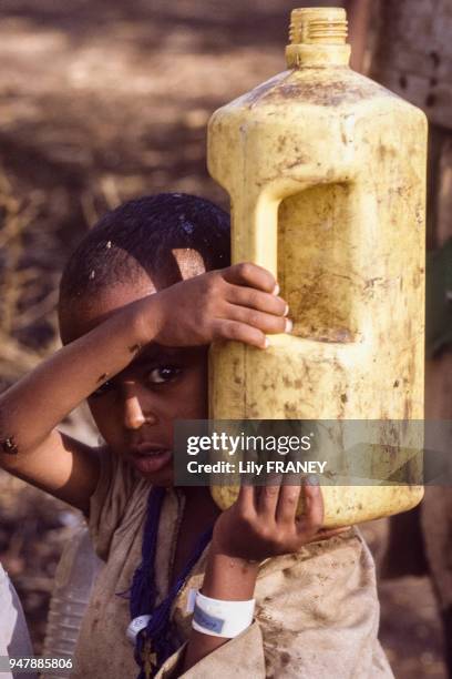 Enfant éthiopien transportant un bidon d'eau, dans un camp de réfugiés au Soudan, en juin 1985.